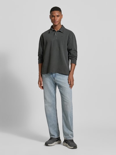 Męski model nosi Loose Fit Poloshirt aus Baumwolle Modell 'Thiago' von Wood Wood, czarny, bawełna, polokraga, label-stitching, długość pleców w rozmiarze M: 71 cm, pełny widok z przodu