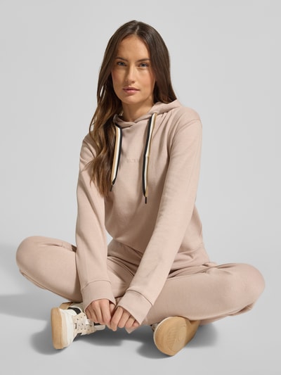 Vrouwenmodel draagt Regular Fit Hoodie uit lyocellmix van BOSS, look: effen, pasvorm: regular fit, labelprint, capuchon met tunnelkoord, lange mouw, detailopname van voor.