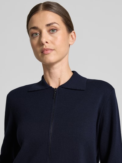 Frauenmodel trägt Strickjacke aus reiner Schurwolle Modell 'SNACK' von MM by Max Mara in Dunkelblau mit Umlegekragen, Nahaufnahme Oberkörper.