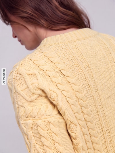 Vrouwenmodel draagt Regular fit pullover uit pure scheerwol model 'ALBEN' van Weekend Max Mara in lichtgeel met kabelstructuur, detailopname, KI-modificeerd beeld