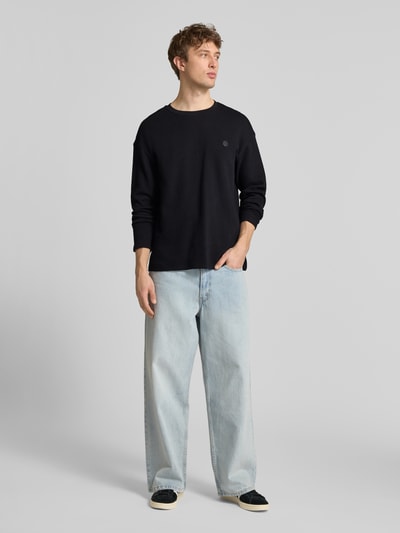 Männermodel trägt Longsleeve aus Baumwolle Modell 'FILLIP' von Blend in Schwarz, Gerader-Schnitt, Rundhalsausschnitt, Label-Detail, Ganzkörperansicht von vorne.