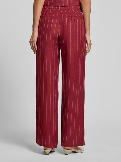 Frauenmodel trägt Wide Fit Leinenhose mit Viskose-Anteil Modell 'Claritte' von MSCH Copenhagen, Leinen-Mix, rot mit weißen Streifen, Eingriff- und Gesäßtaschen, Bundweite bei Größe S 37 cm, Innenbeinlänge 81 cm, Ganzkörperansicht Rückansicht.