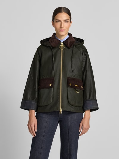 Frauenmodel trägt Regular Fit Funktionsjacke aus reiner Baumwolle Modell 'CARVILLE' von Barbour, dunkles Grün mit braunen Akzenten, Nahaufnahme Oberkörper, Damen Funktionsjacke von Barbour.