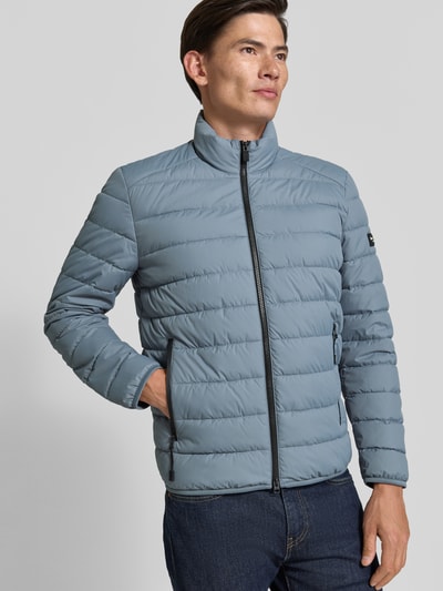 Männermodel trägt Regular Fit Steppjacke mit Zweiwege-Reißverschluss von Marc O'Polo in Hellblau mit mattem Finish, Ganzkörperansicht von vorne. Herren Steppjacke von Marc O'Polo.