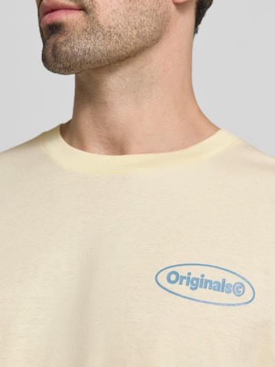 Männermodel trägt Herren T-Shirt von JACK & JONES aus Reine Baumwolle in Hellgelb mit blauem Logo-Print, Nahaufnahme Oberkörper. Modell 'RIVIERA VINTAGE POSTER', Straight Fit, Rundhalsausschnitt.