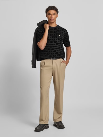 Männermodel trägt T-Shirt mit Label-Stitching von Emporio Armani aus Lyocell-Baumwoll-Mix, Regular-Fit, Schwarz, Ganzkörperansicht von vorne.