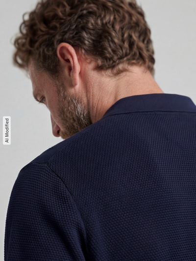 Männermodel trägt Slim Fit Poloshirt mit Strukturmuster von Christian Berg Men in Dunkelblau, reine Baumwolle, Nahaufnahme Rückansicht.
