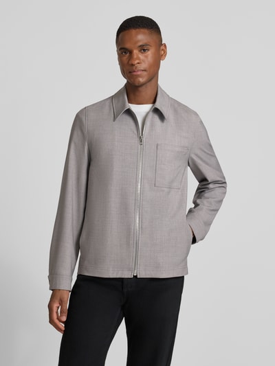 Männermodel trägt Regular Fit Jacke mit Viskose-Anteil Modell 'Jerson' von Drykorn in Hellgrau, sichtbare Brusttasche und Reißverschluss, Ganzkörperansicht von vorne.