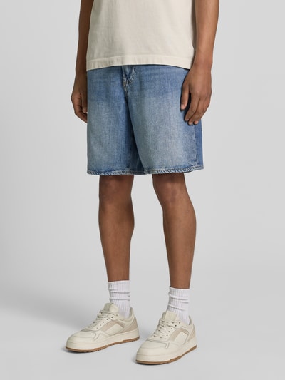 Männermodel trägt Bermudas im 5-Pocket-Design von GAP, aus Baumwoll-Lyocell-Mix, Loose-Fit, mittelblau, Nahaufnahme Unterkörper, Vorderansicht.