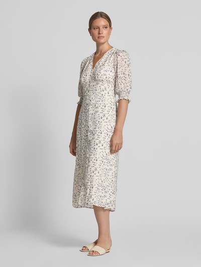 Frauenmodel trägt Midikleid mit floralem Allover-Print Modell 'Valley' von Neo Noir, tailliert, V-Ausschnitt, Halbarm, Ganzkörperansicht von vorne.