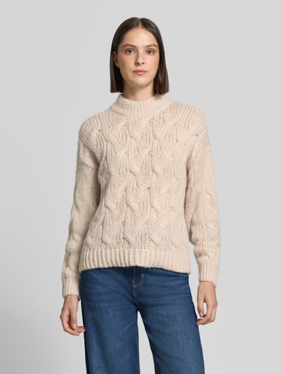 Frauenmodel trägt Regular Fit Pullover mit Rundhalsausschnitt Modell 'MAYBE' von VERO MODA in Beige mit grobem Strickmuster, Ganzkörperansicht von vorne.