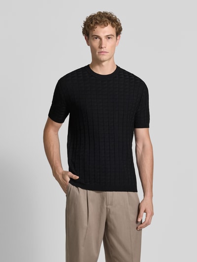 Männermodel trägt Strickshirt aus Viskose-Mix mit Strukturmuster von Armani Exchange in Schwarz, Rundhalsausschnitt, Ganzkörperansicht von vorne.