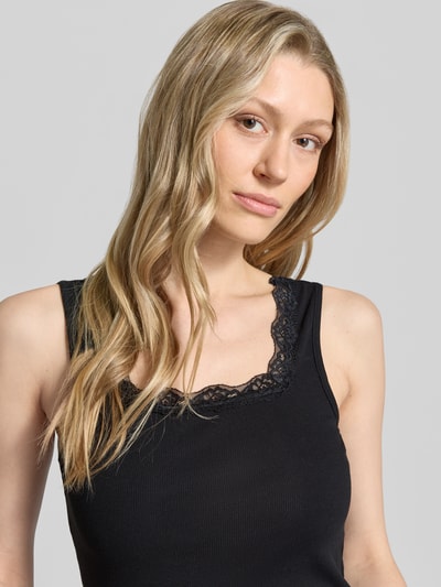 Frauenmodel trägt Regular Fit Top mit Spitzenbesatz von Jake*s Casual, ärmelloses Design, schwarze Farbe, Körpernahe Passform, Nahaufnahme Oberkörper.