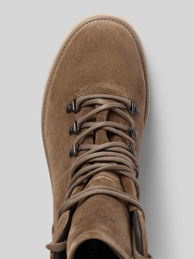 Produktfoto, Boots aus echtem Leder mit Strukturmuster von Woolrich in Beige, abgerundete Passform, Metallösen, strukturierte Oberfläche, Nahaufnahme Oberteil. Absatzhöhe 4 cm, Schafthöhe 14 cm, Schaftweite 10 cm, Logo-Detail am Schaft.