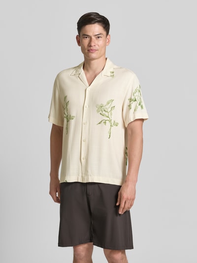 Männermodel trägt Regular Fit Freizeithemd aus reiner Viskose Modell 'TERRY' von SELECTED HOMME in Creme mit grünem Blumenmuster, Ganzkörperansicht von vorne.
