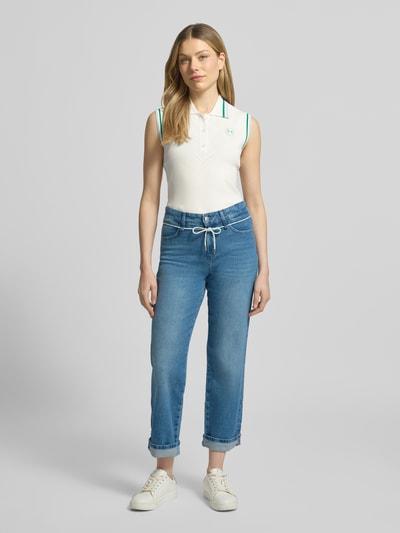Vrouwenmodel draagt Regular Fit Weste aus Viskose-Mix in Strick-Optik van Marc Cain, gebroken wit met polokraag en logo, dames weste, voorkant full body shot