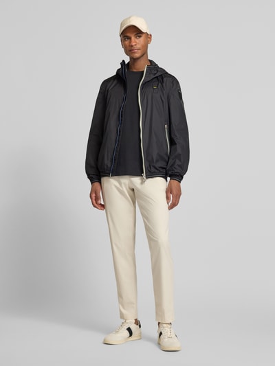 Männermodel trägt Jacke mit Label-Patches Modell 'Dodge' von Blauer Usa, Gerader-Schnitt, Kapuze, Zweiwege-Reißverschluss, seitliche Reißverschlusstaschen, elastische Abschlüsse, Ganzkörperansicht von vorne