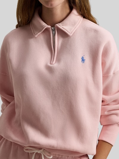 Frauenmodel trägt Sweatshirt mit Label-Stitching von Polo Ralph Lauren, rosa Baumwoll-Mix, lockerer Schnitt, Nahaufnahme Oberkörper.