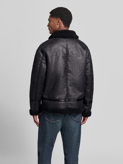 Männermodel trägt Regular Fit Jacke in Leder-Optik von Lindbergh mit Kunstfellbesatz, Umlegekragen, schwarze Farbe, Ganzkörperansicht Rückansicht. Rückenlänge 74 cm, Schulterbreite 50 cm, Brustweite 47 cm, Ärmellänge 60 cm.