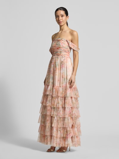 Kobiece model prezentuje 'Abendkleid mit Carmen-Ausschnitt und Volantsaum' von Jake*s Cocktail, tiul, linia a, długa sukienka, dekolt carmen, marszczenia, dół obszyty falbaną, zapięcie na haftkę i zamek błyskawiczny, długość tyłu w rozmiarze 36: 150 cm, szerokość w rozmiarze 36: 39 cm; widok całej sylwetki z przodu.