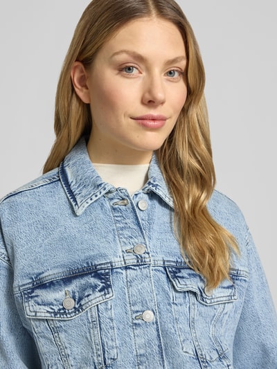 Frauenmodel trägt Regular Fit Jeansjacke aus Baumwoll-Mix Modell 'TESSA' von Vero Moda, efekt: jednolity kolor, denim, wyhaftowane logo, karczek, patka, wykładany kołnierz, mankiety, kieszenie na piersi i wpuszczane, mieszanka bawełny, Nahaufnahme Oberkörper.