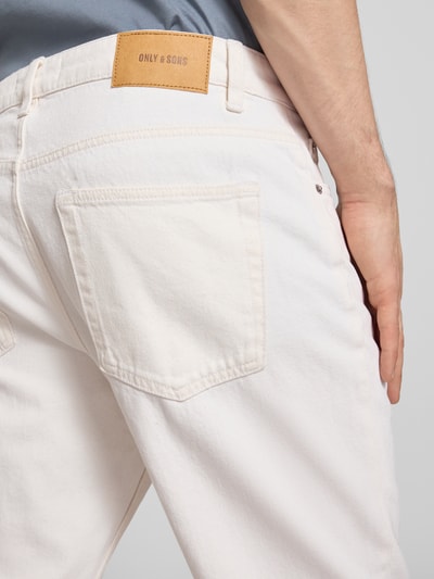 Männermodel trägt Straight Fit Jeans aus reiner Baumwolle Modell 'EDGE' von Only & Sons in Weiß mit Label Patch, Nahaufnahme Rückansicht.