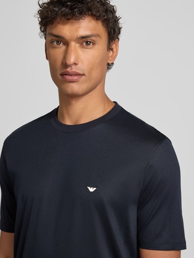 Männermodel trägt T-Shirt mit Label-Stitching von Emporio Armani in Dunkelblau, Lyocell-Baumwoll-Mix, Regular Fit, Nahaufnahme Oberkörper.