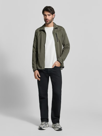 Männermodel trägt Regular Fit Jacke mit Stehkragen Modell 'Berthold' von Icepeak in Oliv mit Napoleontasche, Reißverschluss, elastische Abschlüsse, Ganzkörperansicht von vorne, Rückenlänge 74 cm, Schulterbreite 46 cm, Brustweite 52 cm, Ärmellänge 71 cm.