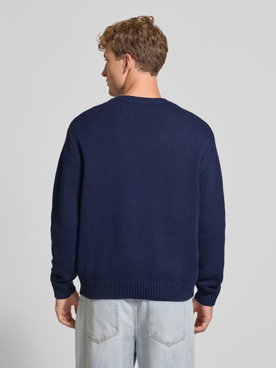 Männermodel trägt Regular Fit Strickpullover aus Baumwoll-Mix von REVIEW in Dunkelblau mit gerippten Abschlüssen, Ganzkörperansicht Rückansicht.
