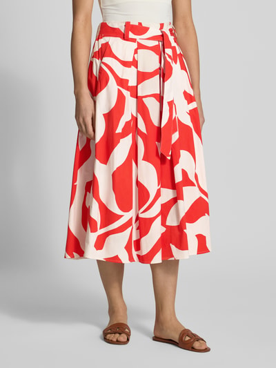 Frauenmodel trägt Regular Fit Midirock mit floralem Allover-Print von More & More aus mieszanka bawełny, fałdy, odpinana tasiemka w talii, szerokość w rozmiarze 36: 37 cm, całkowita długość w rozmiarze 36: 87 cm, kwiatowy nadruk na całej powierzchni w odcieniach czerwieni i bieli, gładka tekstura, Ganzkörperansicht von vorne.
