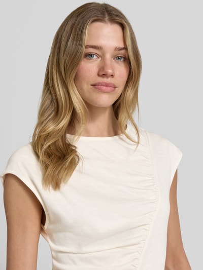 Vrouwenmodel draagt T-shirt met ronde hals en draperingen van Christian Berg Woman, mix van katoen en micromodal, slim fit, kapmouwen, ruglengte bij maat S 56 cm, detailopname bovenlichaam.
