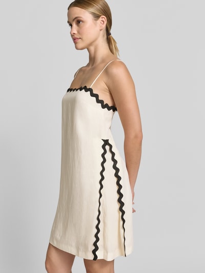 Frauenmodel trägt Leicht ausgestelltes Minikleid aus Lyocell-Leinen-Mix Modell 'KABARU' von HUGO, Two-Tone-Optik, Kontraststreifen, Mini-Länge, Karree-Ausschnitt, verstellbare Spaghettiträger, ohne Ärmel, verdeckter Reißverschluss, gerade Textur, cremiges Beige mit schwarzen Details, Ganzkörperansicht von vorne.