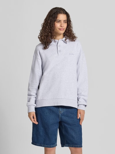 Frauenmodel trägt Oversized Sweatshirt mit Polokragen und Label-Print von OH APRIL in Hellgrau, reine Baumwolle, Ganzkörperansicht von vorne.