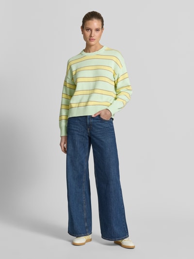 Kobiece model prezentuje sweter z dzianiny z okrągłym dekoltem od GAP, bawełna, krój regular fit, wzór na całej powierzchni, widok z przodu, cała sylwetka.