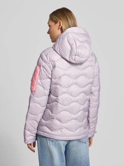 Modelka nosi kurtkę 'Jacke mit Entendaunen-Füllung und Kapuze' od PEAK PERFORMANCE, jasnofioletowa, wypełnienie kaczym puchem, prosty krój, kaptur z ściągaczami, haftowane logo, kieszeń z zamkiem na piersi i rękawie, boczne kieszenie, regulowane wykończenia, długość tyłu 65 cm, szerokość ramion w rozmiarze S: 40 cm, szerokość w rozmiarze S: 51 cm, długość rękawów w rozmiarze S: 63 cm, tekstura pikowana, widok całej sylwetki z tyłu.