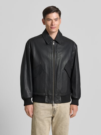 Męski model nosi Regular Fit Lederjacke aus echtem Ziegenleder Modell 'JOSUAL' od BOSS Orange, czarna, teksturowana powierzchnia, Ganzkörperansicht von vorne.