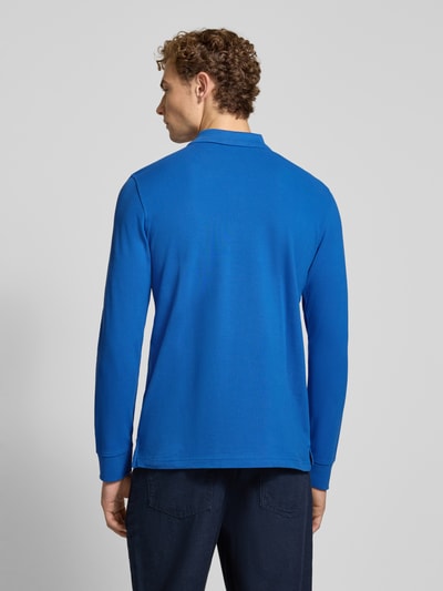 Männermodel trägt Regular Fit Poloshirt aus puur katoen van MCNEAL in effen blauw, labelstitching, polokraag met knoopsluiting, shirt met lange mouwen, ruglengte bij maat M 73 cm, ganzlichaamsaanzicht rugaanzicht.