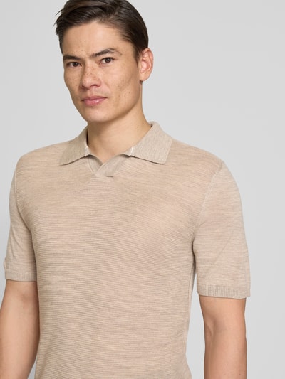 Männermodel trägt Slim Fit Poloshirt aus zuivere scheerwol met structuurpatroon van MAERZ Muenchen in beige, V-hals, heren, ruglengte bij maat 50: 72 cm, nahaufnahme oberkörper.