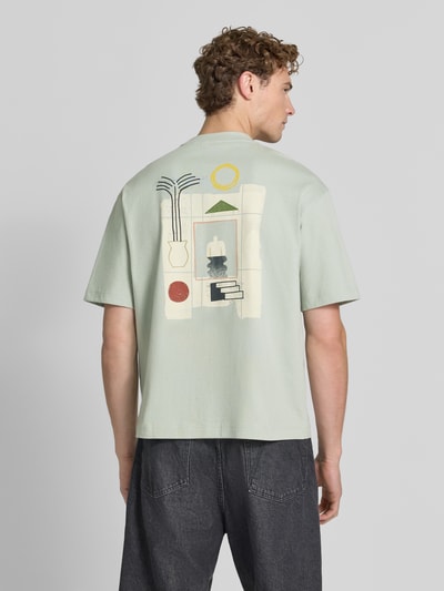 Męski model nosi Relaxed Fit T-Shirt aus reiner Baumwolle Modell 'NORMAN' von Selected Homme w jasnych kolorach, geometryczne wzory na plecach, męski t-shirt, Ganzkörperansicht Rückansicht.