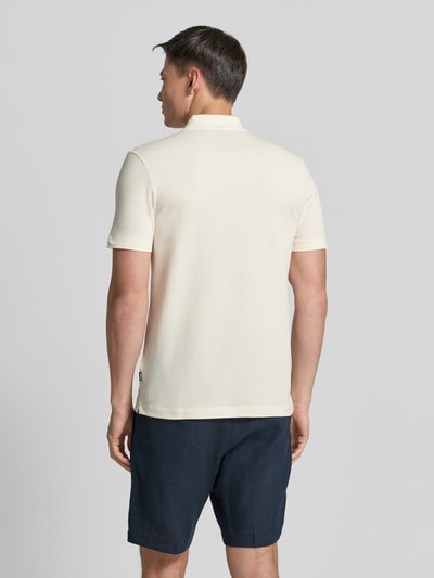 Männermodel trägt Regular Fit Poloshirt aus katoenmix Modell 'PARLAY 240' van BOSS, effen crème, met label patch, korte mouw, rugaanzicht.
