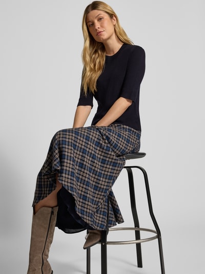 Modelka nosi Strickpullover mit 1/2-Arm und Rundhalsausschnitt von Christian Berg Woman, czarna bawełna, krój slim fit, długość pleców 53 cm, długość rękawa 32 cm, widok całej sylwetki z przodu.