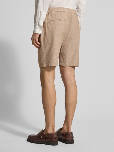 Männermodel trägt Shorts aus Baumwoll-Leinen-Mix mit elastischem Bund von Scotch & Soda in Beige, Regular Fit, Ganzkörperansicht Rückansicht.