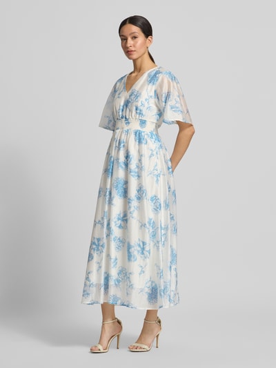 Frauenmodel trägt Midikleid aus Lyocell-Mix Modell 'Evangelia' von MSCH Copenhagen mit blauem Allover-Look und V-Ausschnitt, Ganzkörperansicht von vorne. Rückenlänge bei Größe S: 131 cm, Brustweite: 41 cm, Ärmellänge: 31 cm.