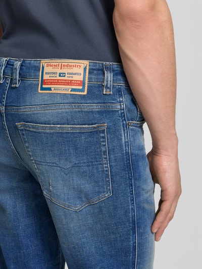 Männermodel trägt Straight Fit Jeans aus Baumwoll-Mix von Diesel, 5-Pocket-Design, Label-Detail, mittleres Blau, Nahaufnahme Rückansicht.
