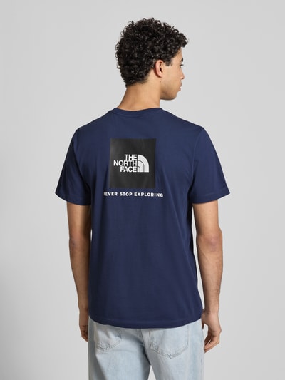 Männermodel trägt Regular Fit T-Shirt aus Baumwoll-Mix Modell 'EVOLUTION' von The North Face, dunkelblau, Label-Detail, Rückenlänge 70 cm, Ganzkörperansicht Rückansicht.