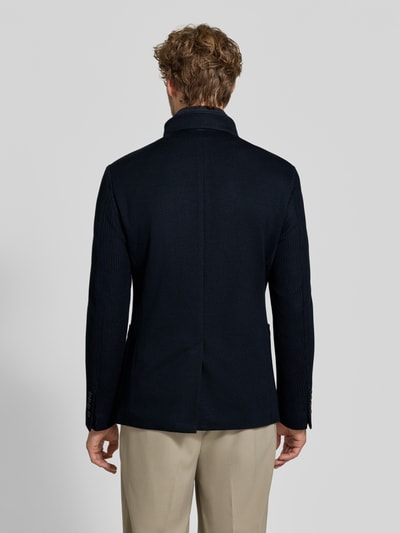Männermodel trägt Slim Fit Sakko mit Woll-Anteil Modell 'Hypetar' von JOOP! COLLECTION in Dunkelblau, glatte Struktur, Ganzkörperansicht Rückansicht.