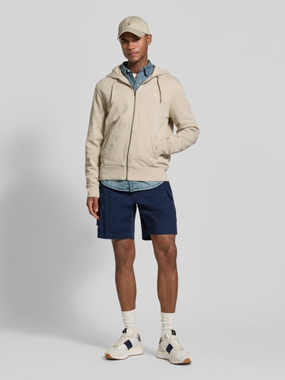 Męski model nosi 'Relaxed Fit Cargoshorts aus reiner Baumwolle' von Polo Ralph Lauren, jednokolorowe, krój relaxed fit, wyhaftowane logo, szlufki na pasek, zapięcie na guzik i kryty zamek błyskawiczny, wpuszczane kieszenie, tylne kieszenie z guzikiem, kieszenie cargo, tkana faktura, bawełna, całopostaciowy widok z przodu.