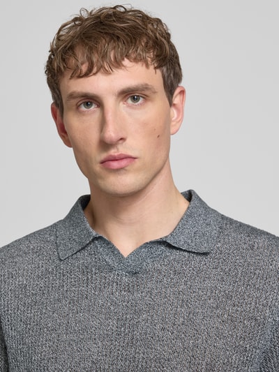 Männermodel trägt Regular Fit Strick-Poloshirt Modell 'CASSIS' von Jack & Jones aus reiner Baumwolle, grau meliert, Nahaufnahme Oberkörper.