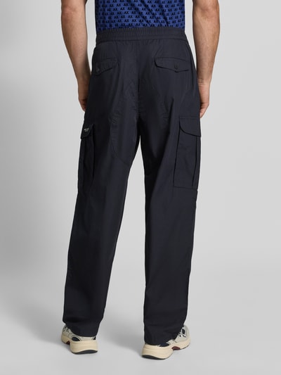 Männermodel trägt Wide Fit Cargo-Hose mit katoenmix von Armani Exchange in zwart met cargozakken, elastische band, Materiaalmix, Ganzkörperansicht Rückansicht. Context: Heren cargo-broek van Armani Exchange, Materiaalmix met katoen, wide fit, elastische band, cargozakken, bandwijdte maat 32/32: 45 cm, binnenbeenlengte maat 32/32: 78 cm.