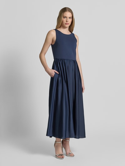 Modelka kobieca ma na sobie Abendkleid mit Rückenausschnitt und breiten Trägern von Christian Berg Cocktail, materiał z dodatkiem stretchu, A-linia, midikleid, okrągły dekolt, szerokie ramiączka, głęboki dekolt na plecach, długość pleców w rozmiarze 36: 132 cm, szerokość w rozmiarze 36: 40 cm, kolor granatowy, matowa faktura, widok całej sylwetki z przodu.